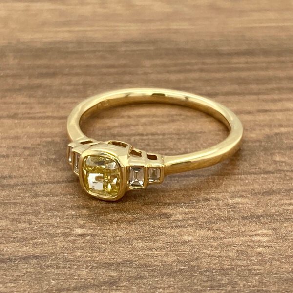 Gold ring with yellow gemstone and diamonds.