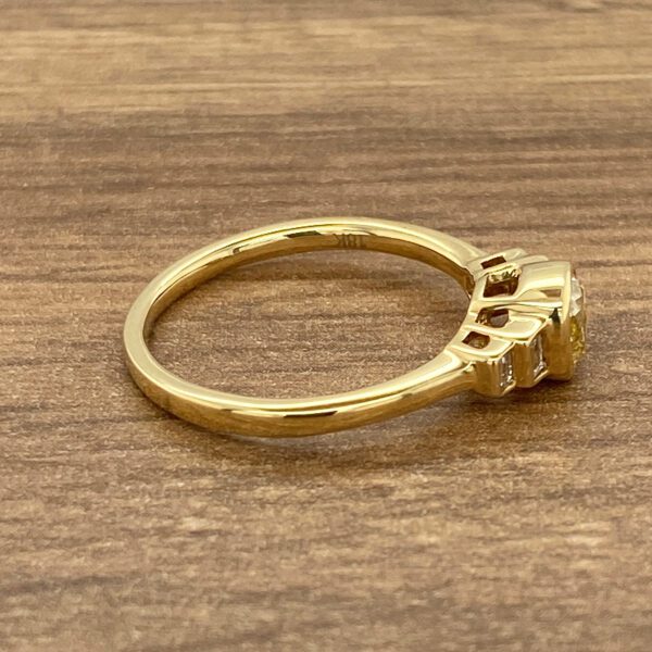 Gold ring with yellow gemstone and diamonds.