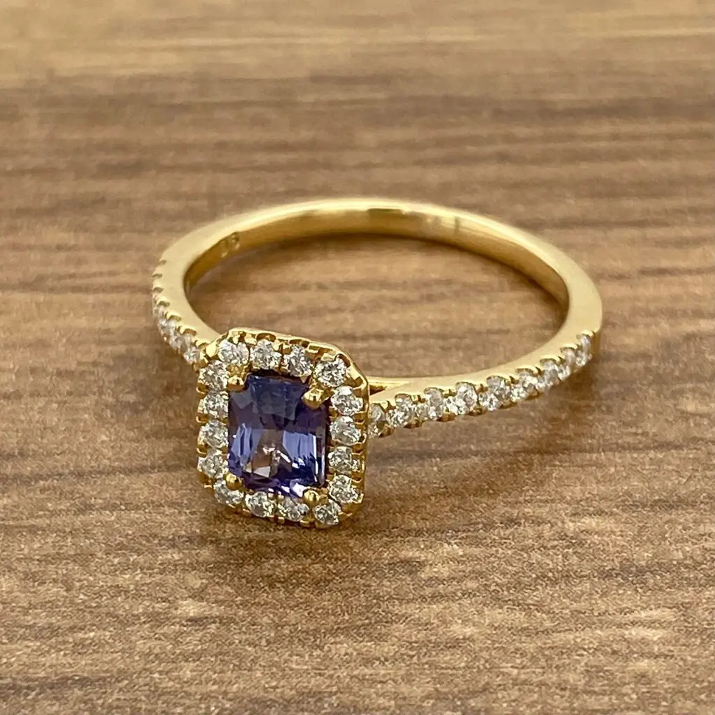 Gold ring with purple gemstone and diamonds.