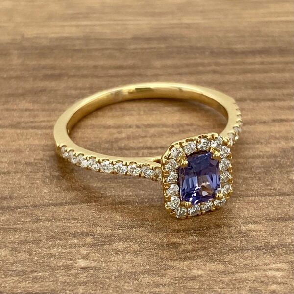 Gold ring with a purple gemstone and diamonds.