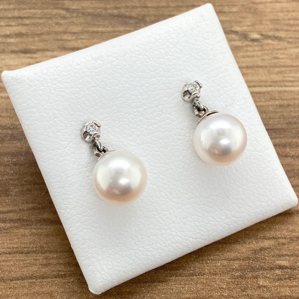 Pair of pearl earrings with diamond accents.