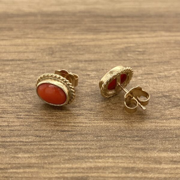 A pair of gold - plated coral stud earrings.