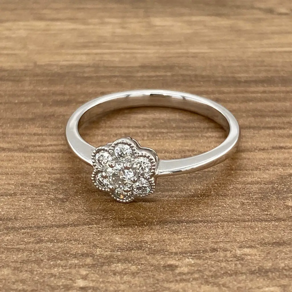 Diamond flower ring on wooden surface.