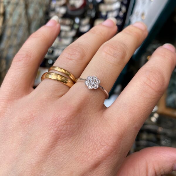 Hand wearing a flower diamond ring.