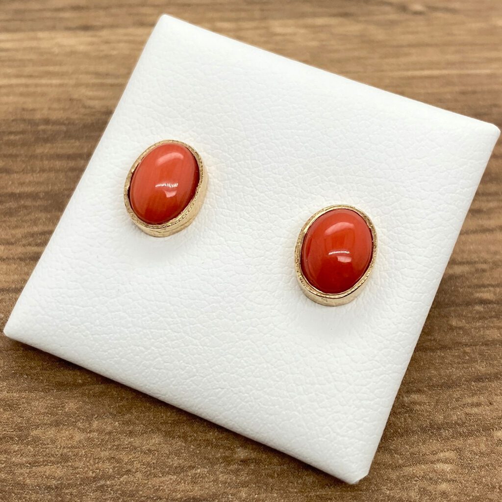 Gold earrings with red coral stones.