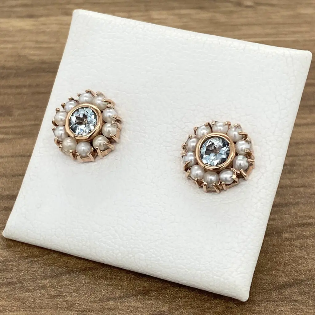A pair of blue topaz and pearl stud earrings.