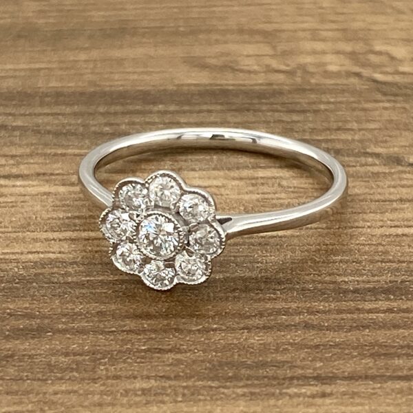 Diamond flower ring on wooden surface.