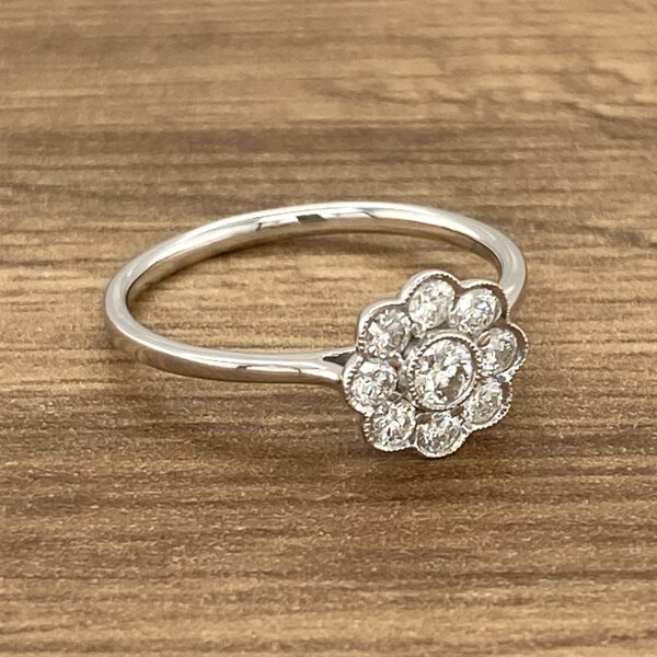 Diamond flower ring on wooden surface.