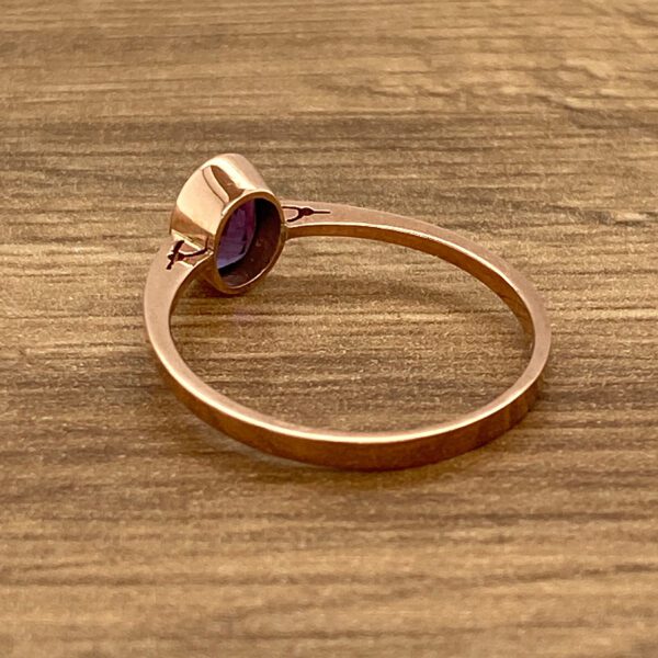 Gold ring with a purple gemstone.