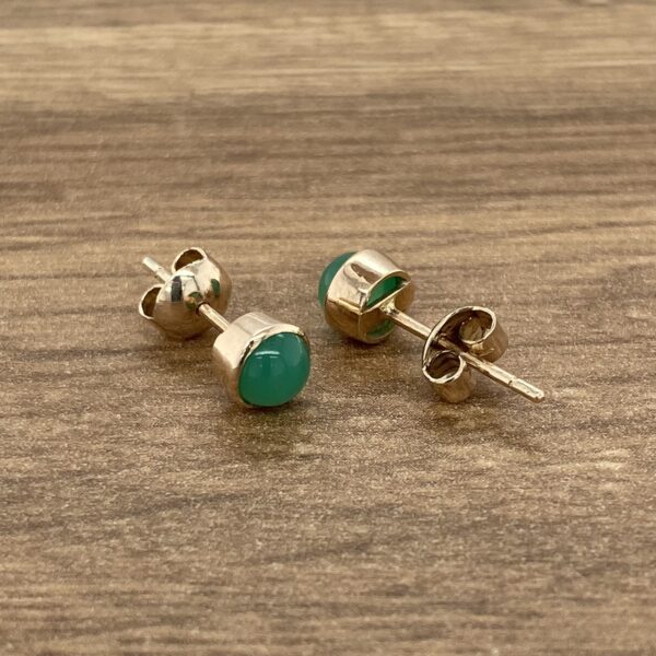 Gold earrings with green gemstones.