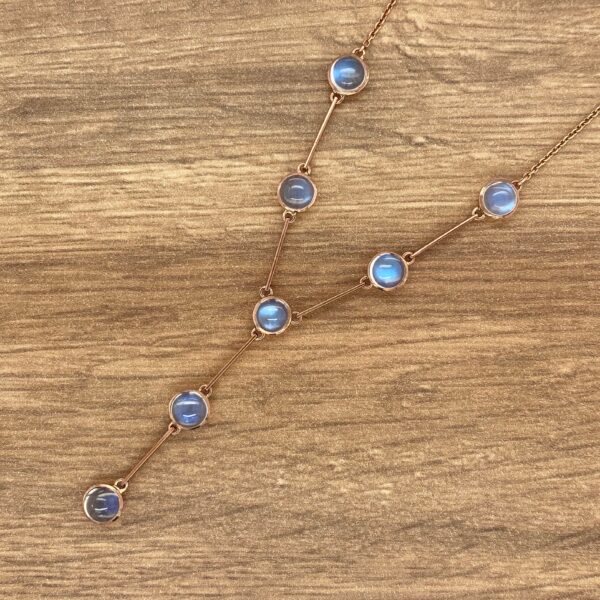 Gold necklace with blue gemstone pendants.