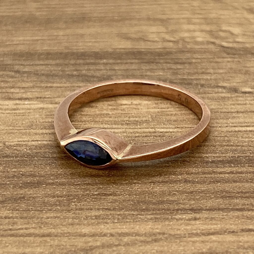 Gold ring with blue marquise gemstone.