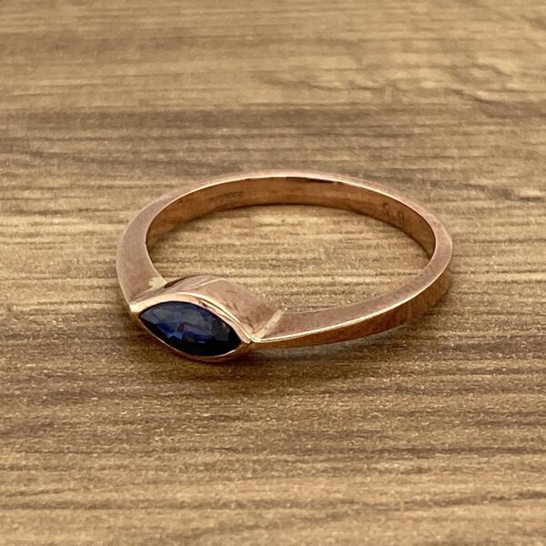 Gold ring with blue marquise gemstone.