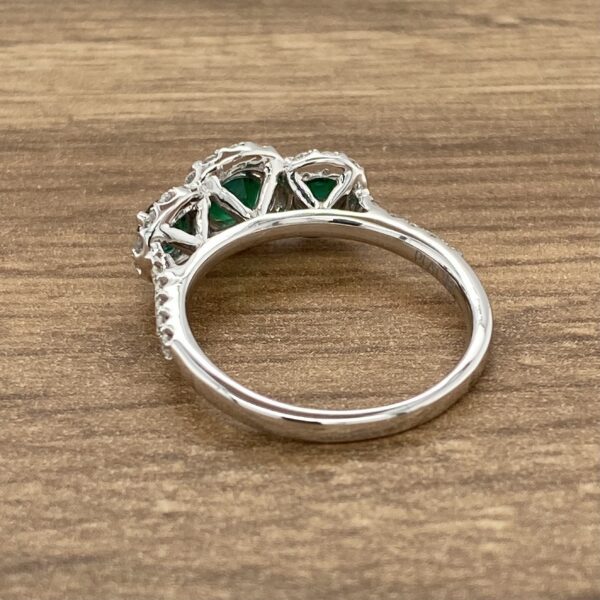 Silver ring with three green gemstones.