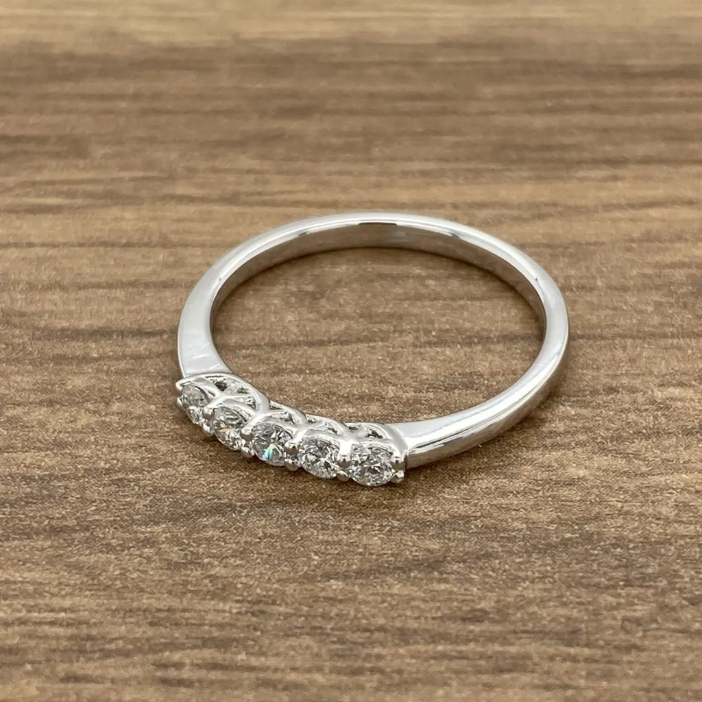 A three stone diamond ring on a wooden table.