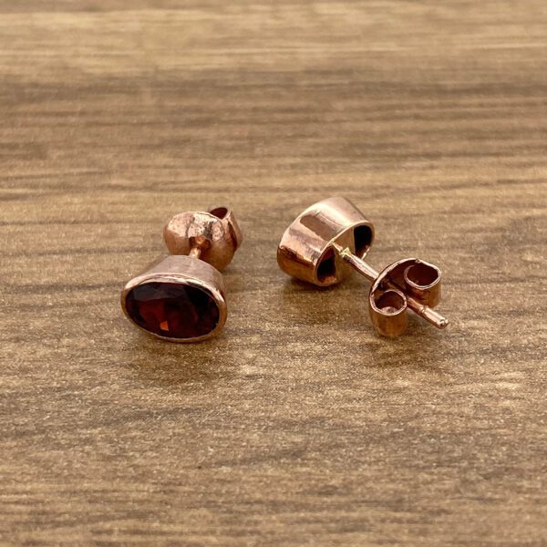 Rose gold stud earrings with red stones.