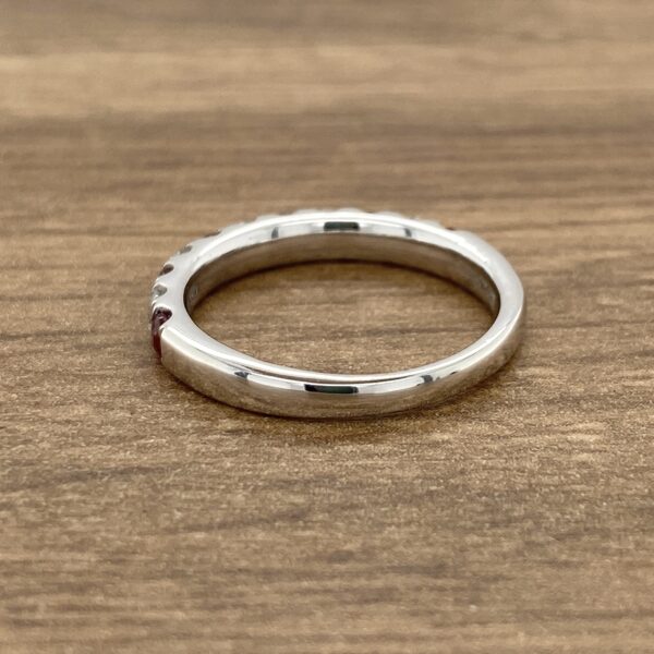 Side view of a silver band with red stones.