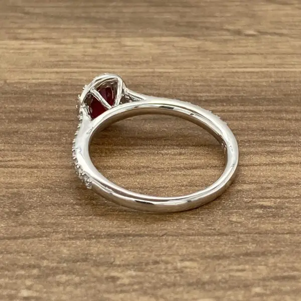 Diamond and ruby engagement ring on wood.