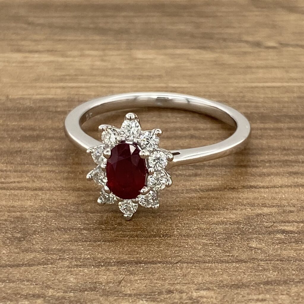 Oval ruby ring with diamond halo.