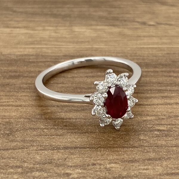 Oval ruby ring with diamond halo setting.