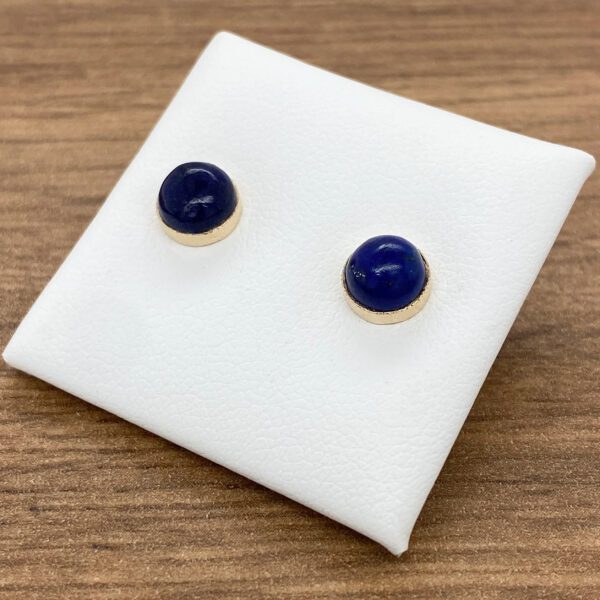 Gold stud earrings with blue gemstones.