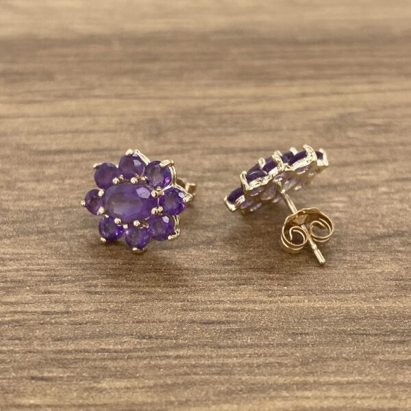 Amethyst flower stud earrings on wood.