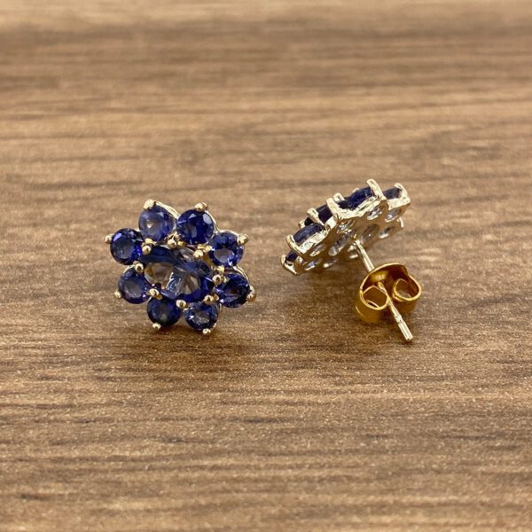 Gold earrings with blue gemstone flowers.