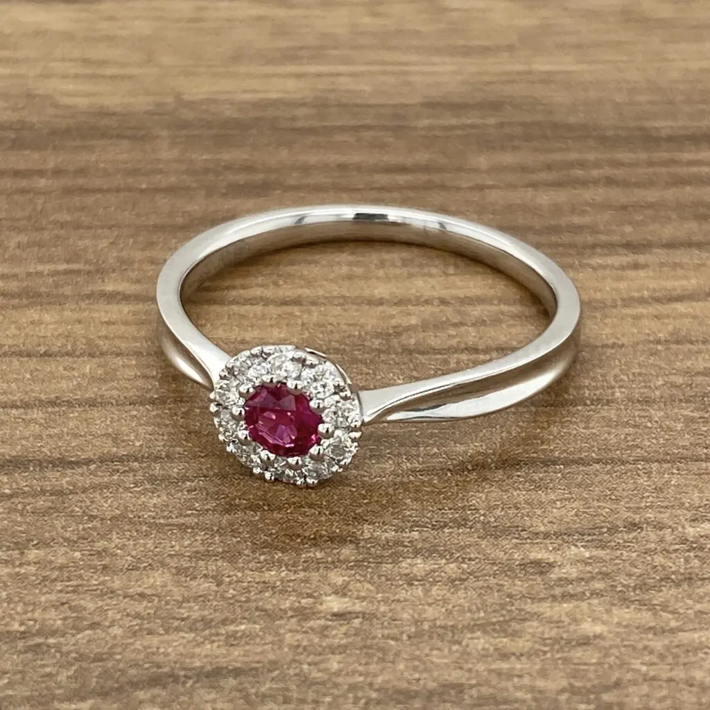 A white gold ring with a ruby stone and diamonds.
