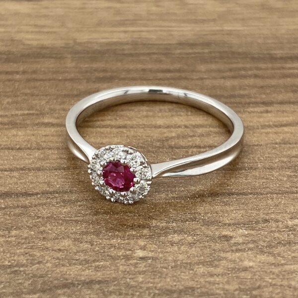 A white gold ring with a ruby stone and diamonds.