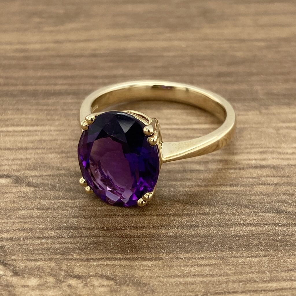 Gold ring with large purple amethyst stone.