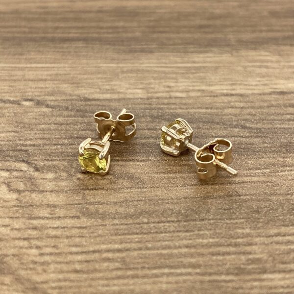 Gold stud earrings with yellow stones.