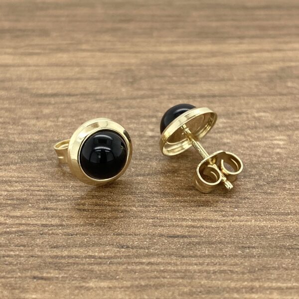 A pair of gold plated black onyx stud earrings.