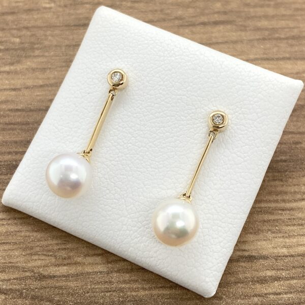 Gold pearl earrings with diamond accents.