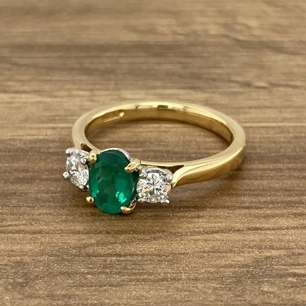 Gold ring with emerald and diamond stones.