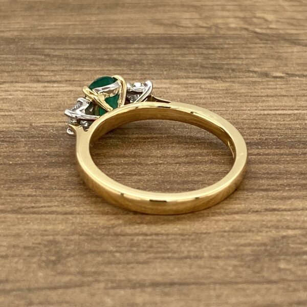 Gold ring with emerald and diamond stones.