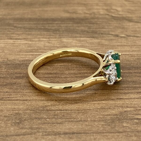 Gold ring with emerald and diamond stones.