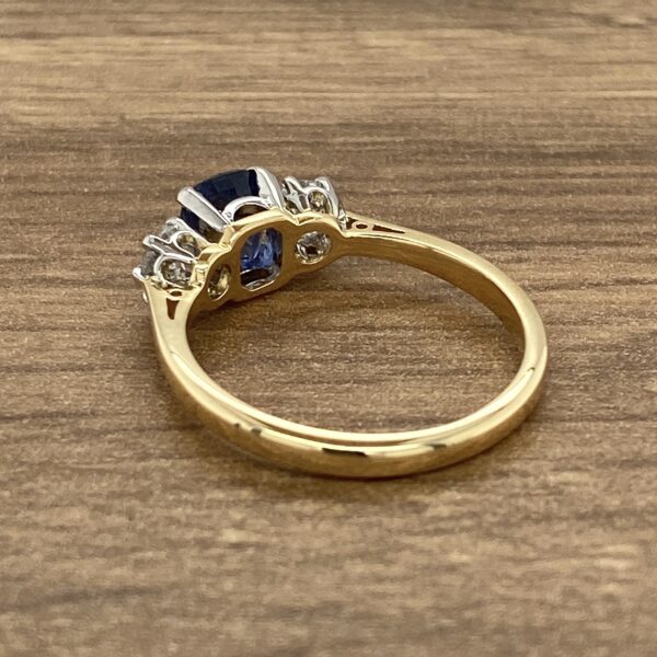 Gold ring with a blue sapphire and diamonds.