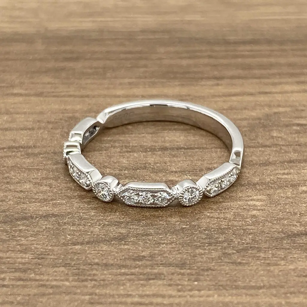 A white gold band with diamonds on top.