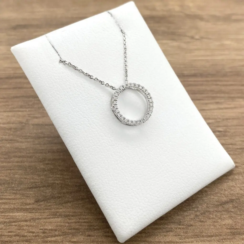 A necklace with a circle of diamonds on a white background.