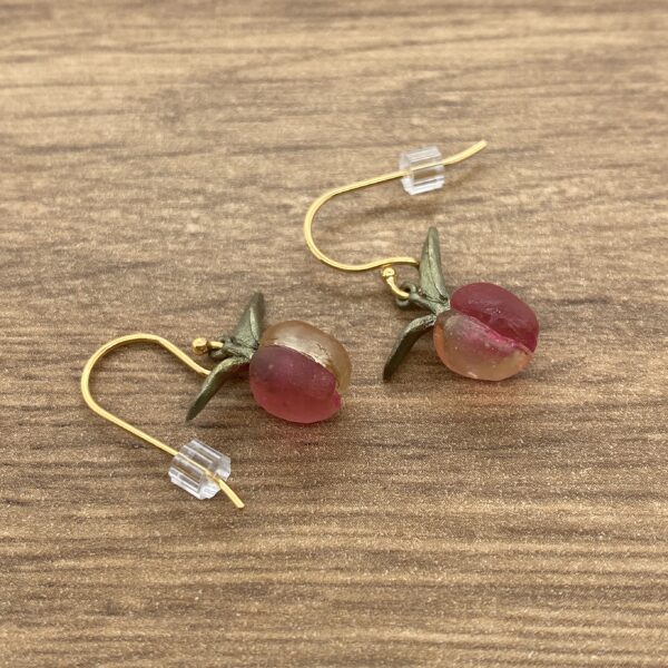 Gold peach earrings with leaves.