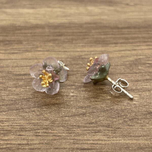 Pink flower stud earrings on wood