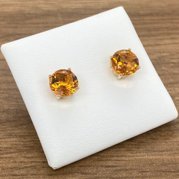 Gold earrings with round citrine stones.