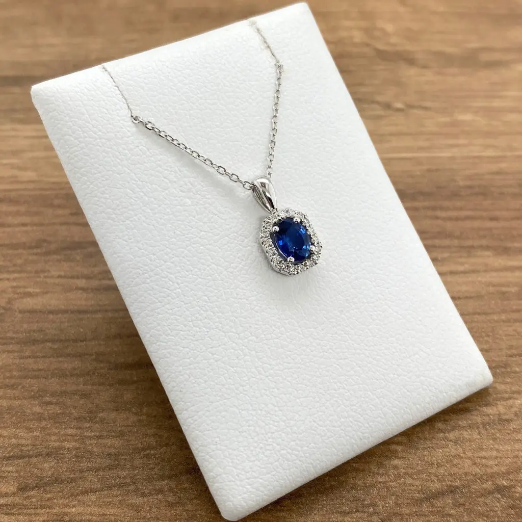 Silver necklace with blue sapphire pendant.