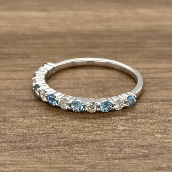 A blue topaz and diamond ring on a wooden table.