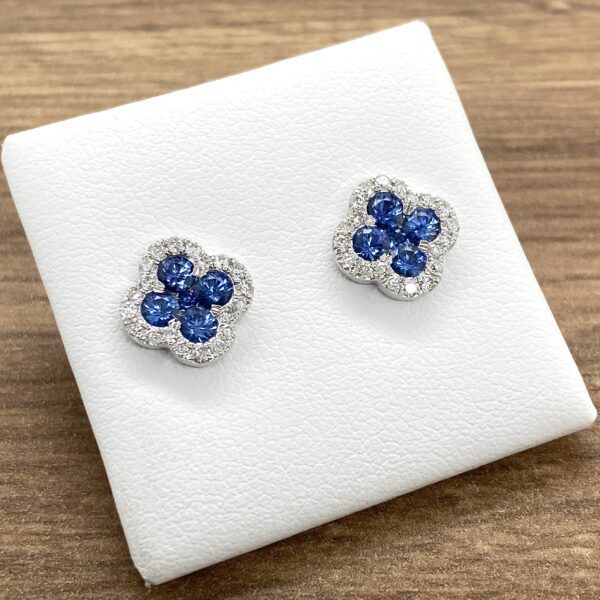 A pair of blue sapphire and diamond stud earrings.