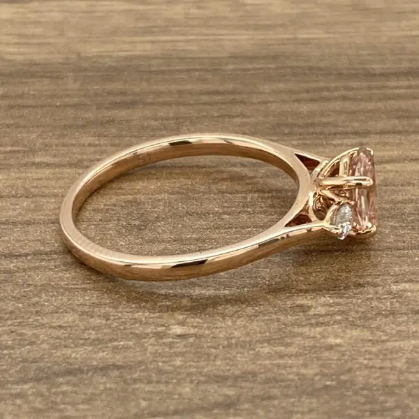 A rose gold ring with a morganite stone and diamonds.