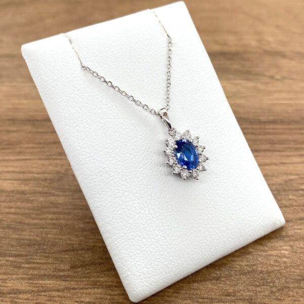 A blue sapphire and diamond necklace on a white background.