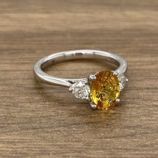 Oval yellow sapphire engagement ring with diamonds.