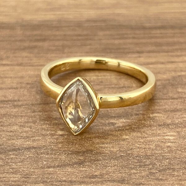 Gold ring with a light brown gemstone.