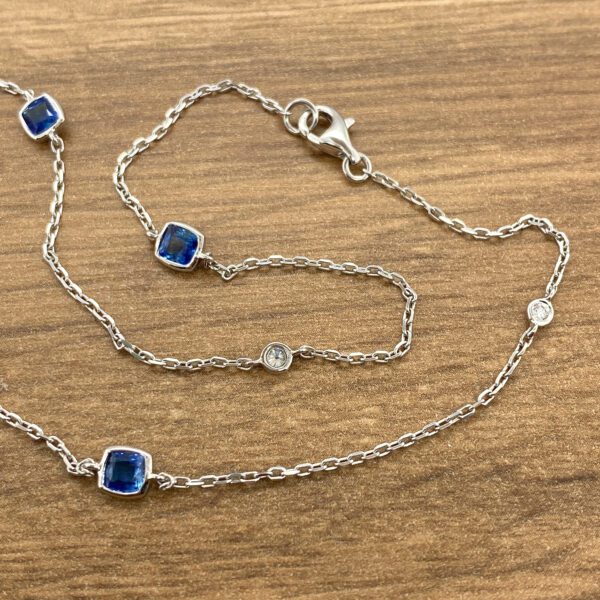 Silver chain necklace with blue and white stones.